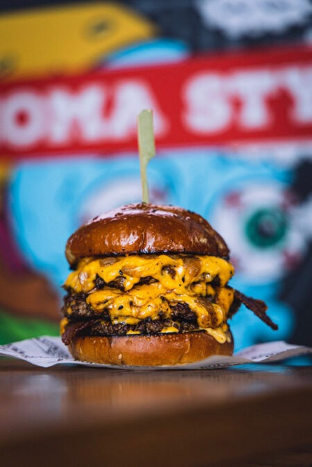 The Dirty Boy boasts a succulent double patty, generously topped with American cheese, Dirty Mayo, beef dripping onions, and crispy bacon.