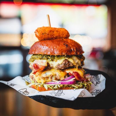 This Rude Boy pictured features 2 patties, Bacon, Green Chilli Salsa, Jack Cheese, Lettuce, Onion, Served With A Jalapeño Popper On Top!