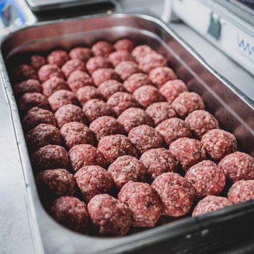 Uncooked burgers in a tray